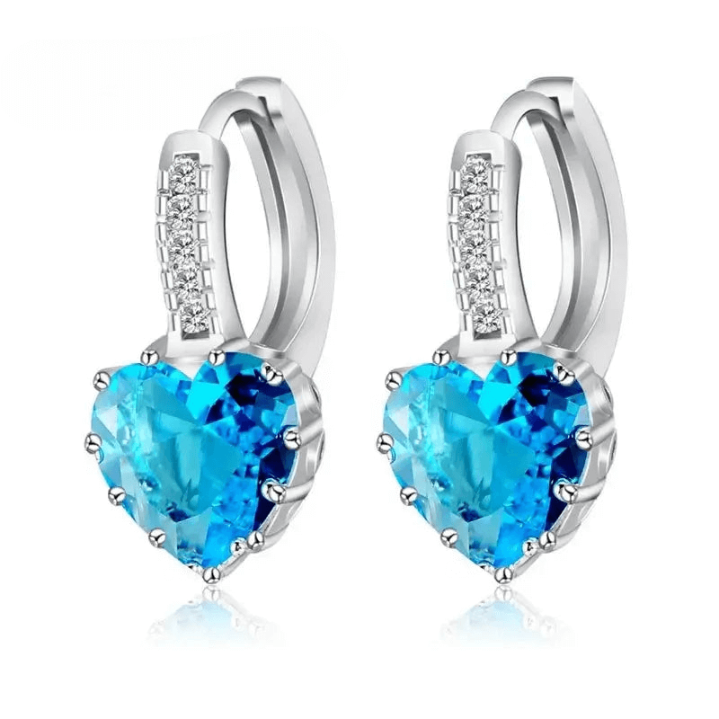 Heart-shaped blue crystal hoop earrings in sterling silver, trendy design perfect for women, occasions like weddings or parties.
