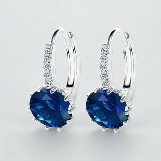 Sterling silver drop hoop earrings with blue cubic zirconia, trendy design for women, perfect for weddings and parties.