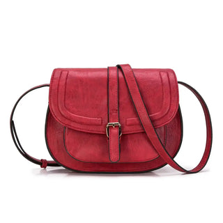 Red leather crossbody bag with a chic shell shape and stylish buckle closure for everyday elegance.