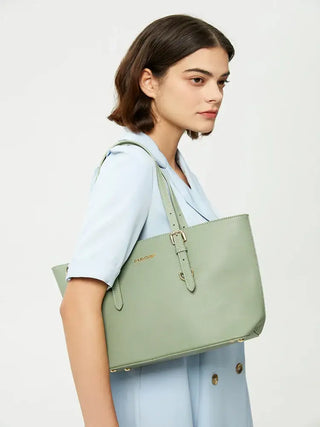 Model showcasing a light green tote bag with adjustable shoulder straps and a zipper closure.