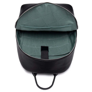 Vintage black faux leather backpack interior showing green lining and organizational pockets.