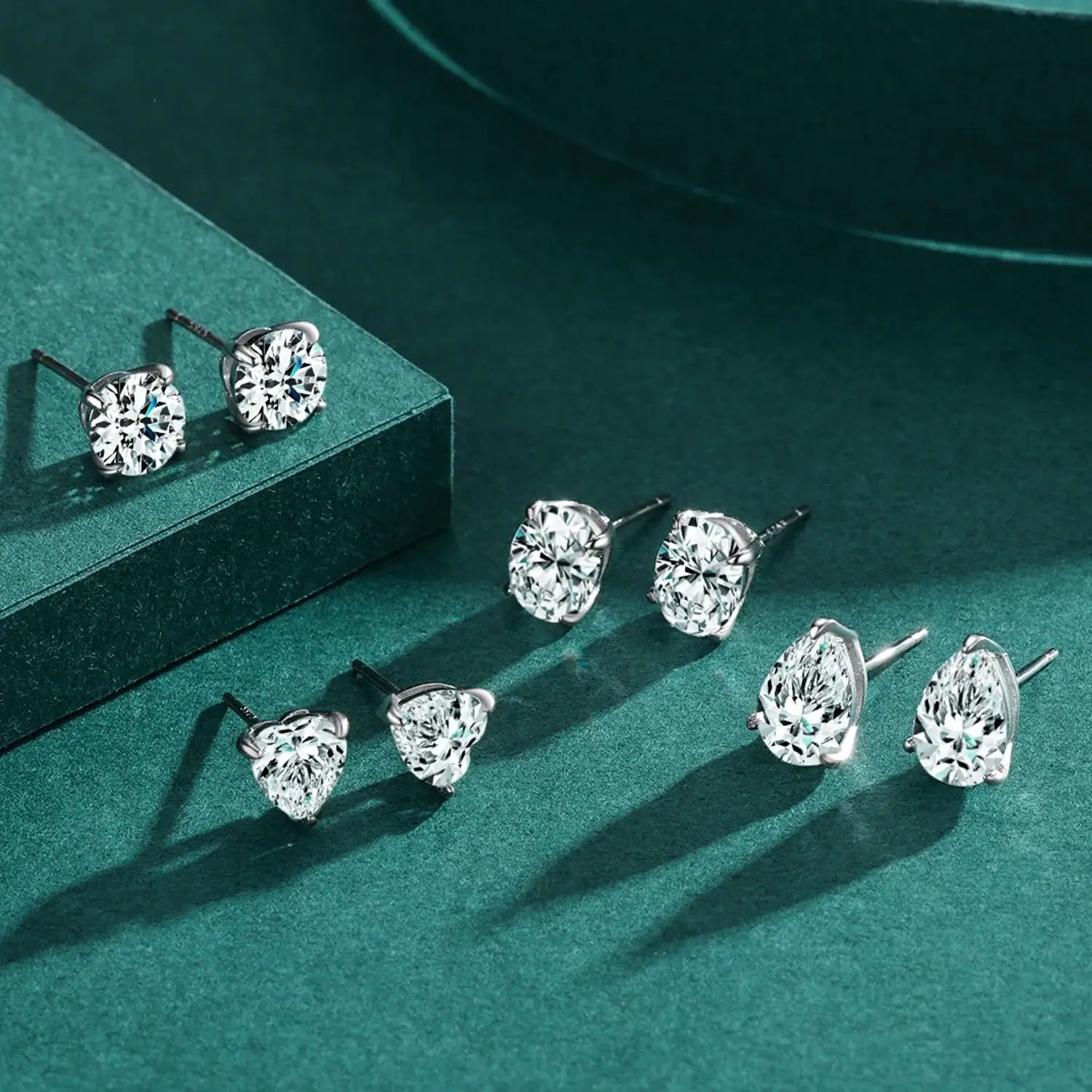 Water Drop Zircon Stud Earrings Set 925 Sterling Silver displayed on a green surface showcasing elegant design.