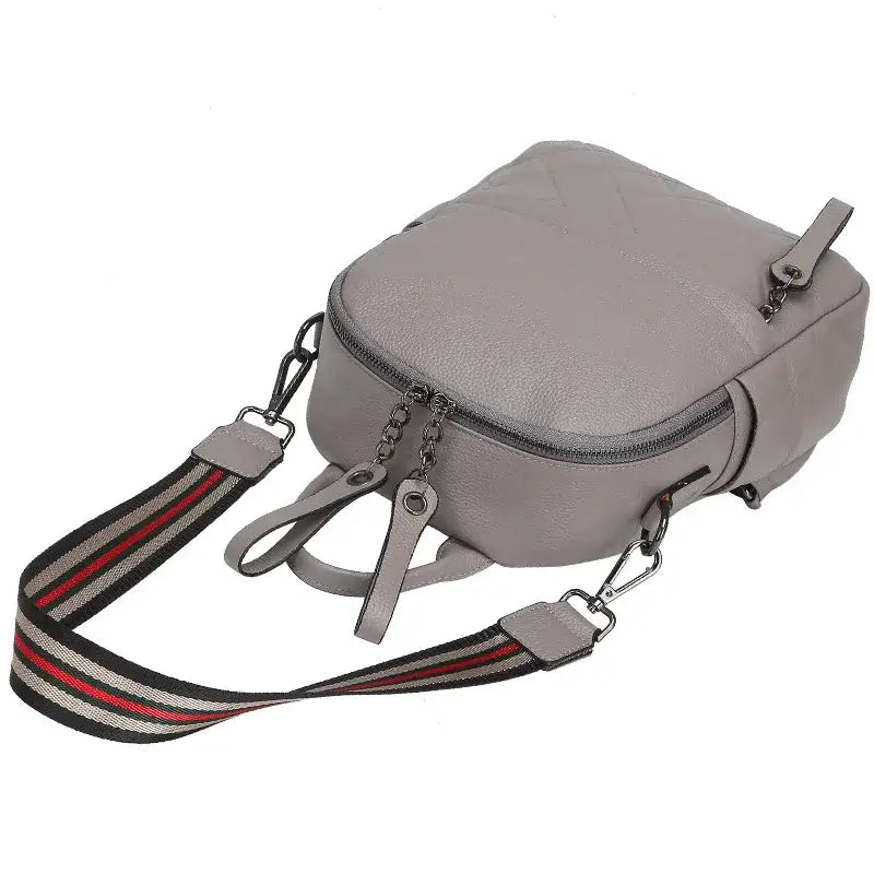 Gray leather crossbody bag with striped strap, practical and stylish for everyday use.