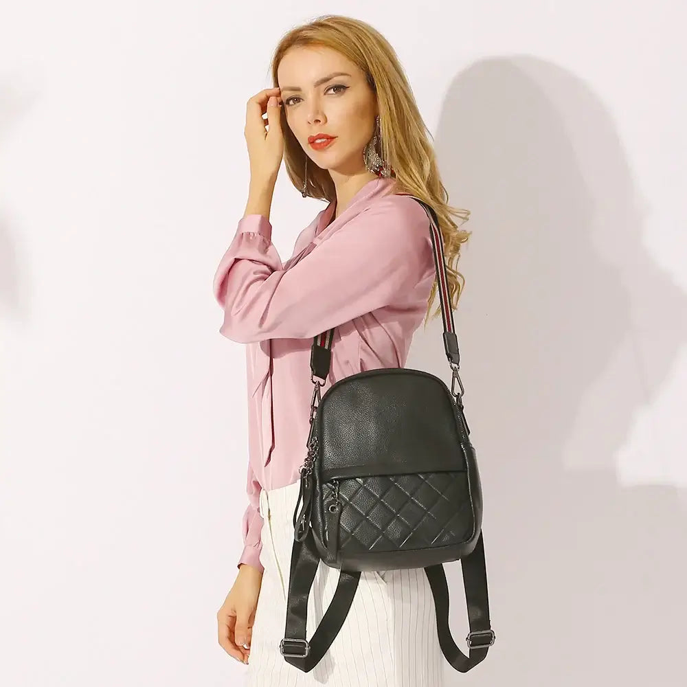 Black leather backpack worn by a woman, featuring quilted texture and adjustable straps for stylish practicality.