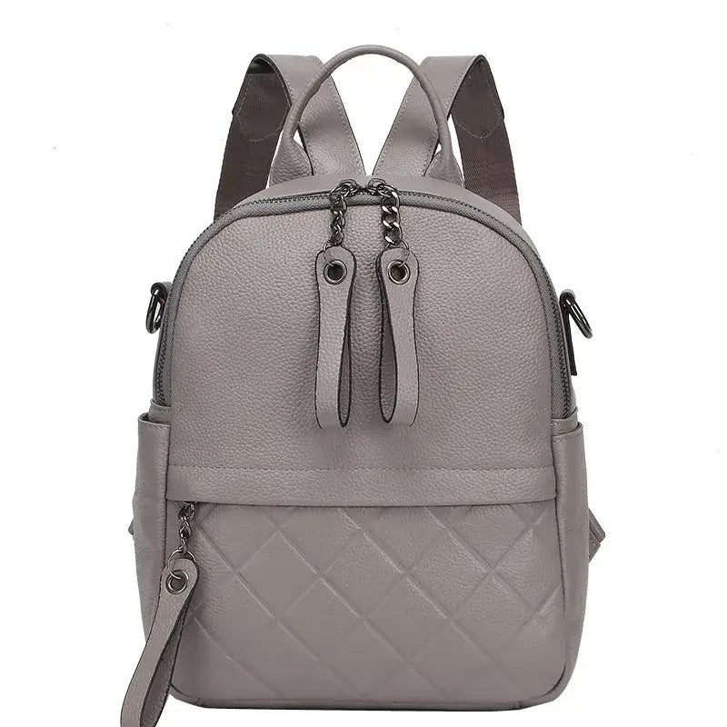 Gray quilted leather backpack for women, stylish and functional with dual zippers and adjustable straps.