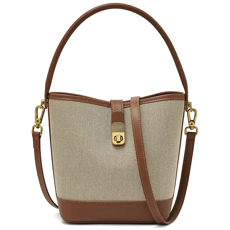 Beige and brown women's bucket bag with top handle, crossbody strap, and gold lock detail for casual style.