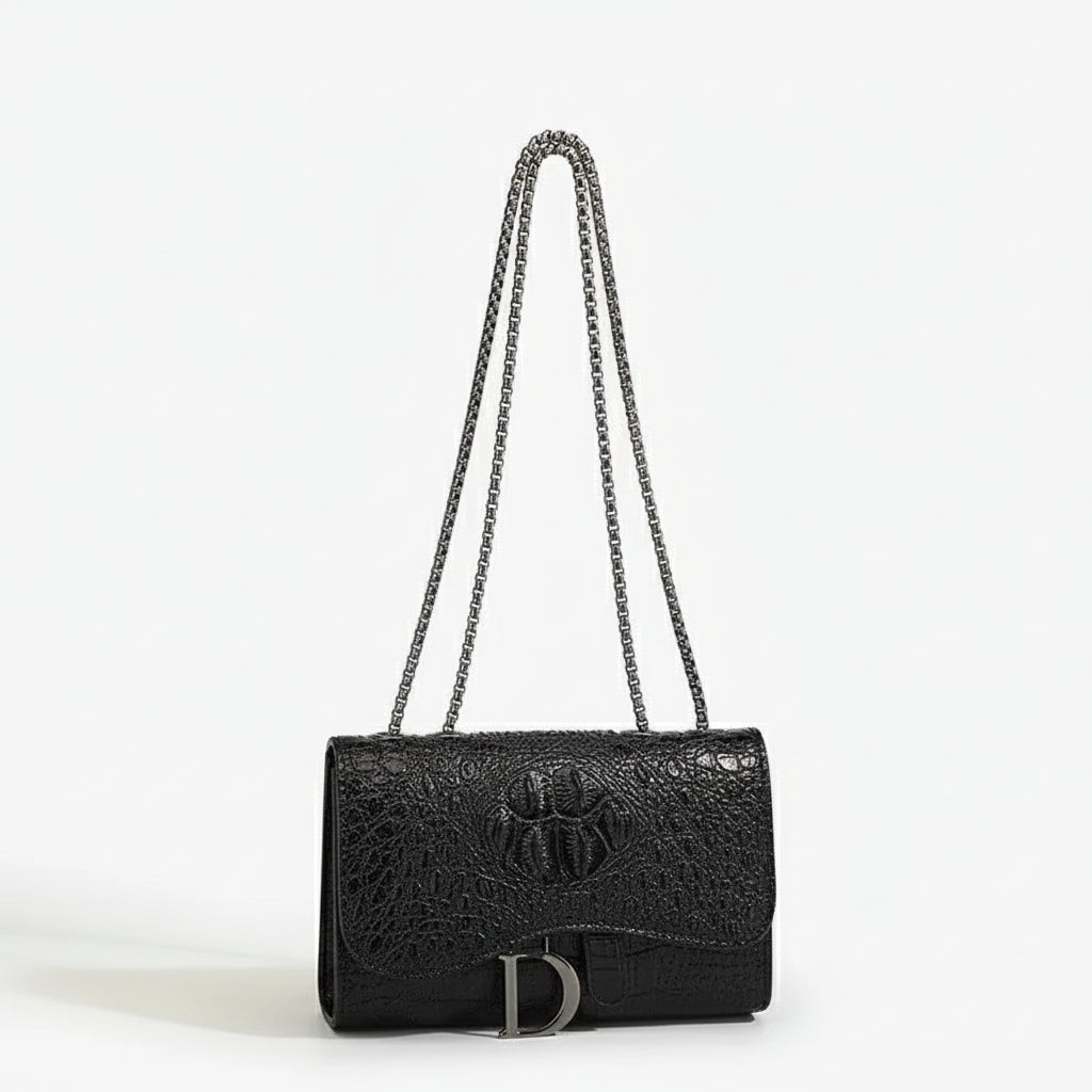 Crossbody bag in black faux leather with chain detail, featuring a chic flap design and spacious interior.