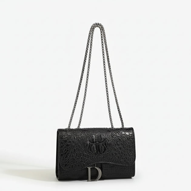 Crossbody bag in black faux leather with chain detail, featuring a chic flap design and spacious interior.