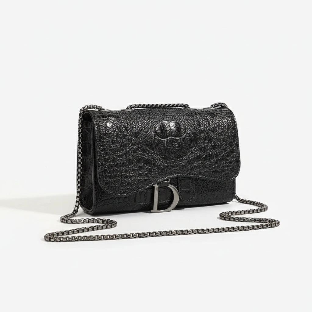 Crossbody bag in black faux leather with chain detail, chic flap design, featuring a stylish animal print texture.