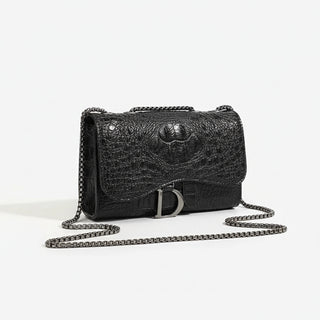 Crossbody bag in black faux leather with chain detail, chic flap design, featuring a stylish animal print texture.