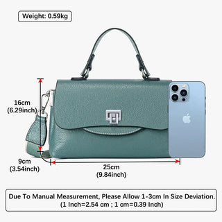 Crossbody bag in teal with measurements for size, featuring a sleek design and modern metallic accent.