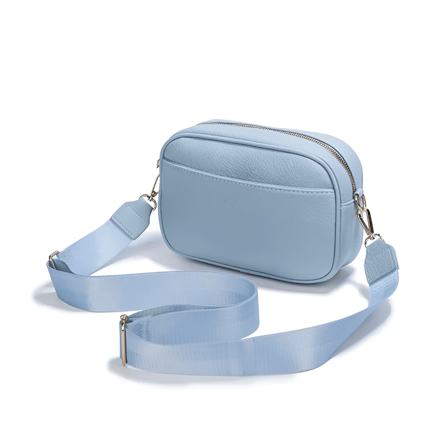 Stylish crossbody bag with wide adjustable strap in light blue PU leather for modern elegance.