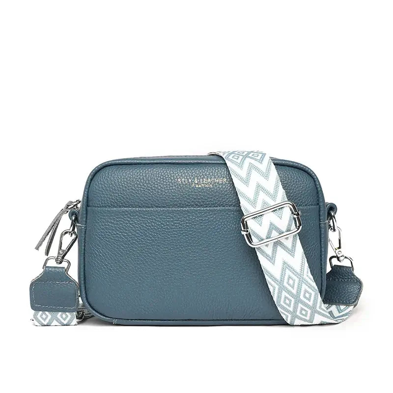 Women’s stylish teal crossbody bag with a geometric strap and zipper closure, perfect for everyday use.