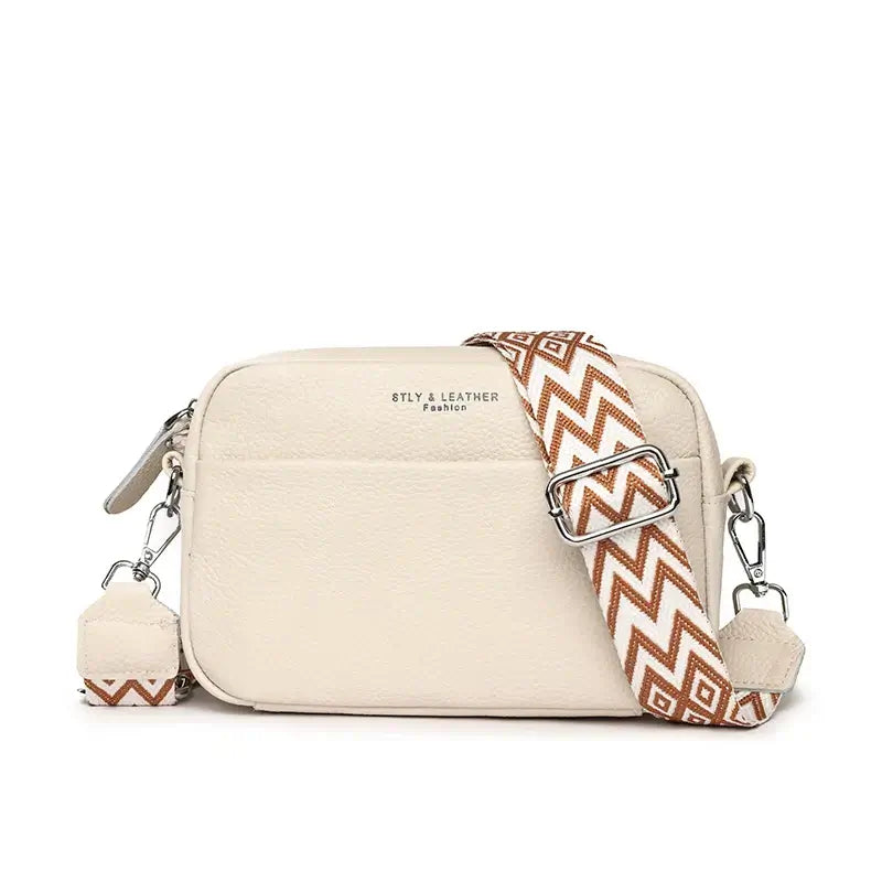 Beige crossbody bag with geometric pattern strap, crafted from genuine leather for stylish and practical use.