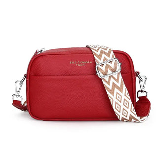 Red leather crossbody bag with adjustable geometric strap and zipper closure, perfect for trendy women's fashion.
