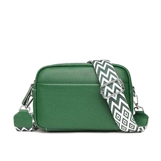 Green crossbody bag with geometric patterned strap, made of premium leather for stylish everyday use.