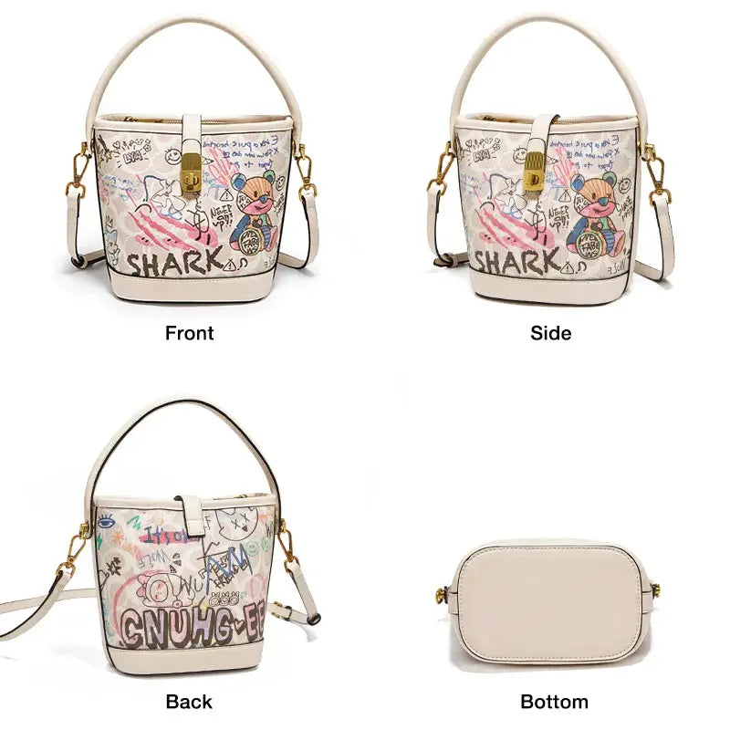 Trendy white women's graffiti print bucket bag with top handle and crossbody strap featuring cartoon design.