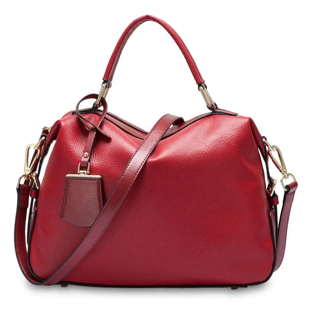Red leather handbag with dual handles and adjustable strap, perfect for stylish everyday use.