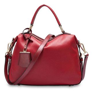 Red leather handbag with dual handles and adjustable strap, perfect for stylish everyday use.