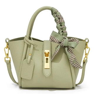 Light green leather handbag with gold lock and scarf handle detail, stylish hobo bag for women.