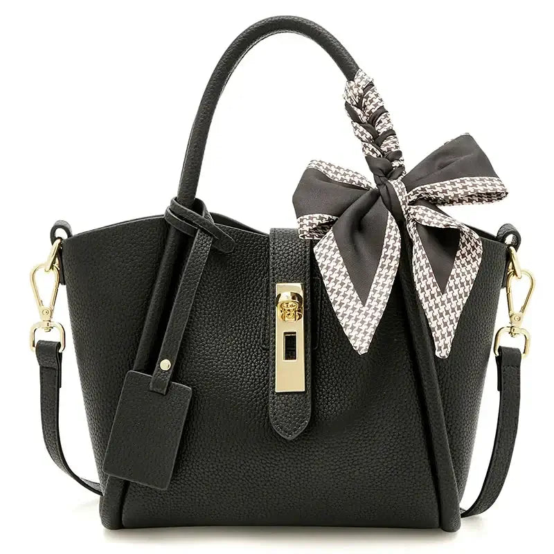 Black leather women's handbag with gold lock and scarf handle detail, stylish hobo bag.