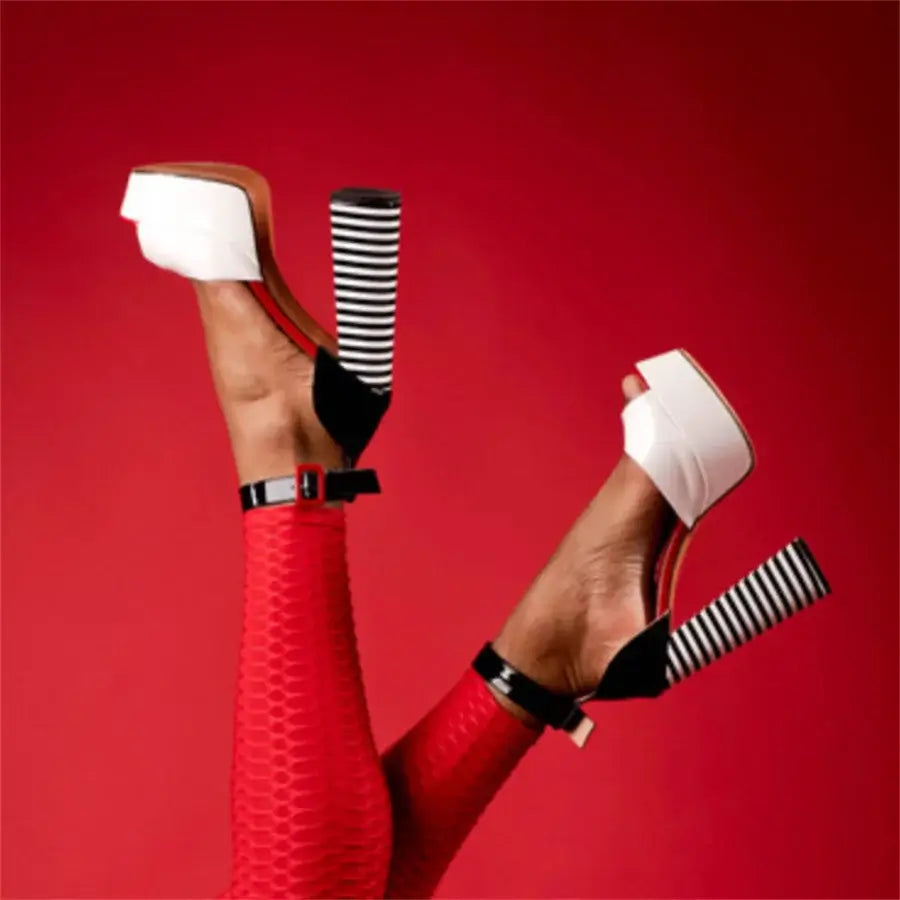 High-quality handmade heels, black and white patent leather platform sandals with dramatic height and ankle-wrap design.