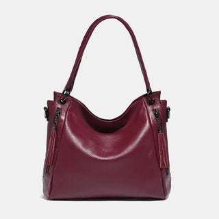 Shoulder hobo bag in burgundy leather with tassel detail, perfect for stylish and comfortable everyday use.