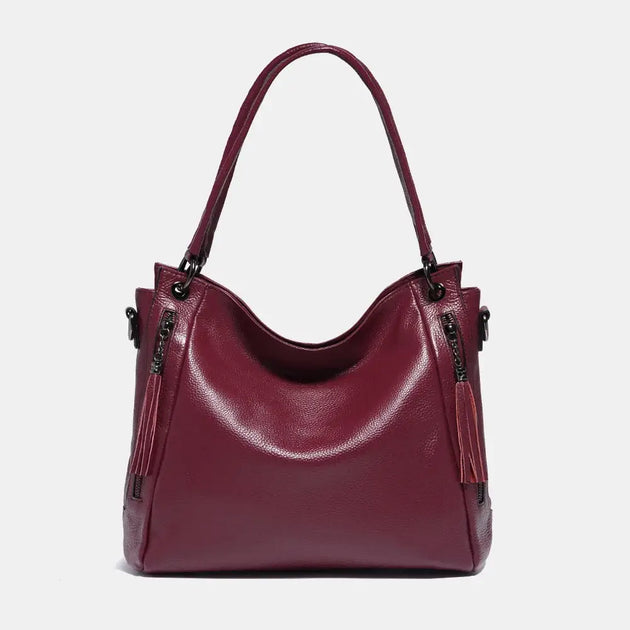 Shoulder hobo bag in burgundy leather with tassel detail, perfect for stylish and comfortable everyday use.
