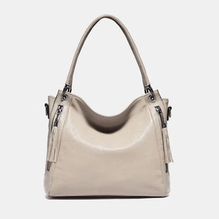 Shoulder hobo bag in soft beige leather, stylish design, spacious with dual straps and tassel detail.