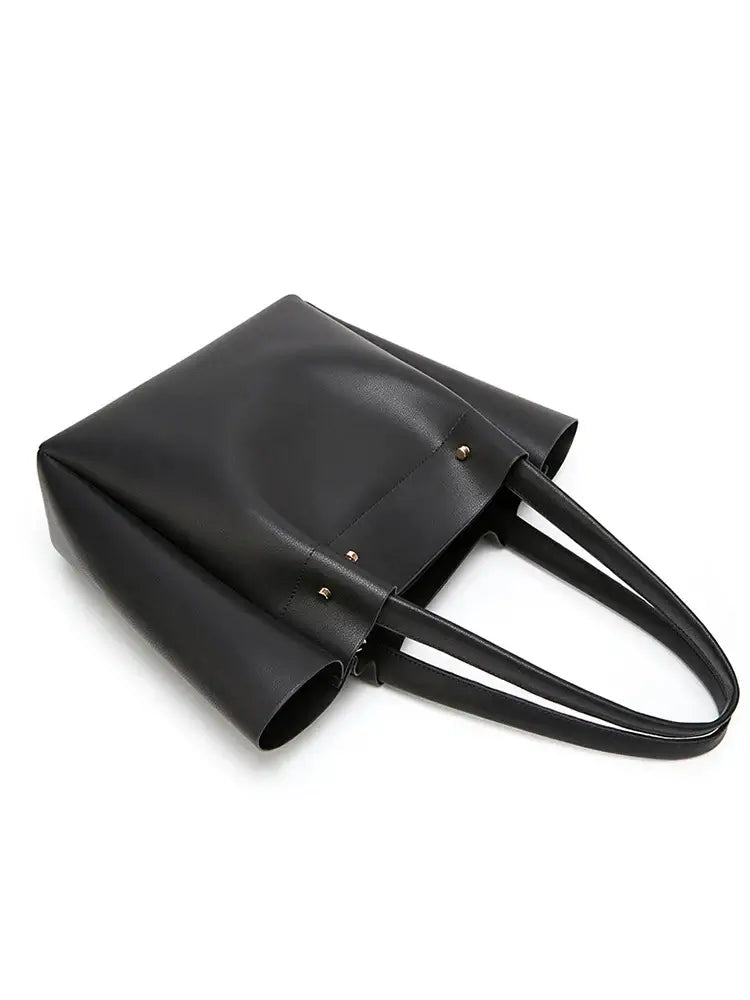 Women's large black tote bag in faux leather with minimalist design, ideal for versatile casual occasions.