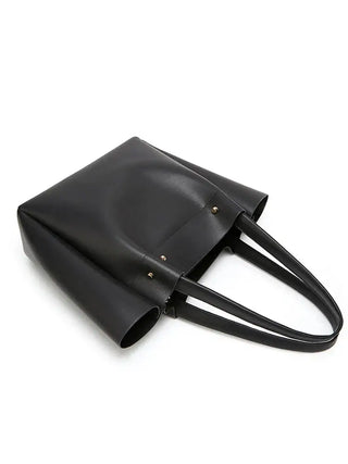 Women's large black tote bag in faux leather with minimalist design, ideal for versatile casual occasions.