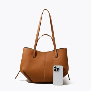 Brown genuine leather tote bag with spacious interior, stylish design and smartphone for scale.