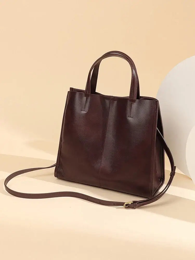 Elegant brown leather handbag, structured satchel style for shoulder and crossbody use, perfect for casual and formal occasions.