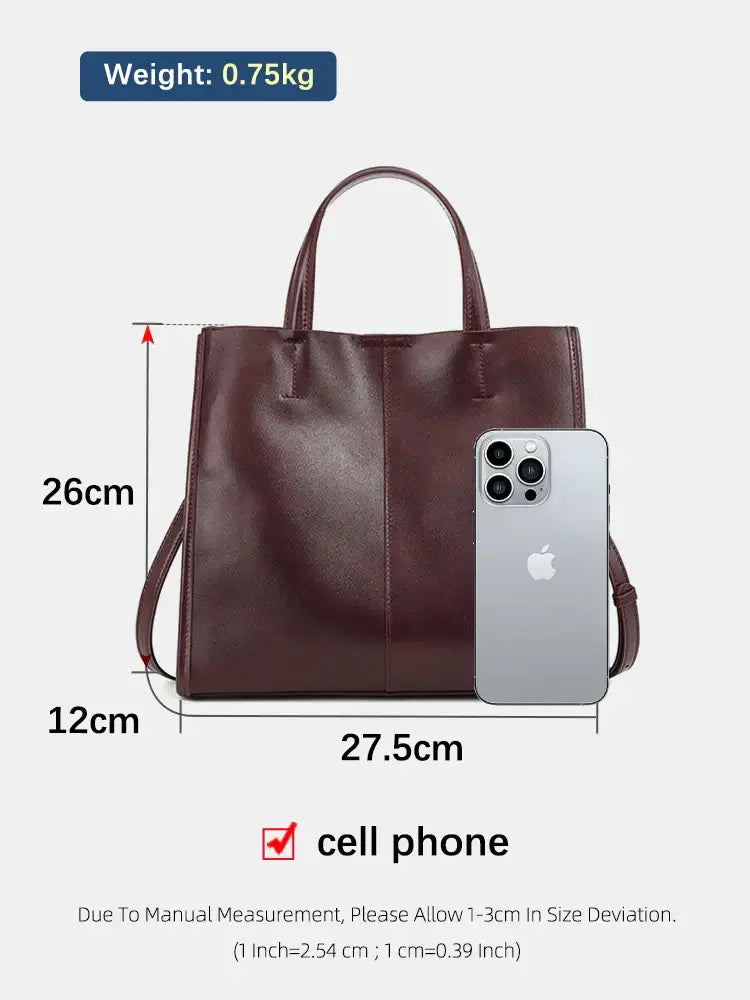 Structured burgundy leather handbag with dimensions, showcasing practicality and elegance next to a cell phone.