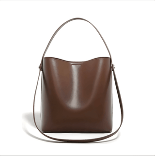 Women's brown leather shoulder bag with top handle and crossbody strap, soft minimalist design, spacious interior.