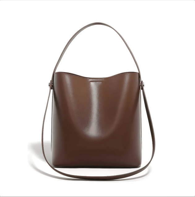Women's brown leather shoulder bag with top handle and crossbody strap, soft minimalist design, spacious interior.