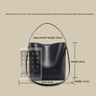 Brown leather shoulder bag with top handle and crossbody strap, featuring a minimalist design and large capacity.