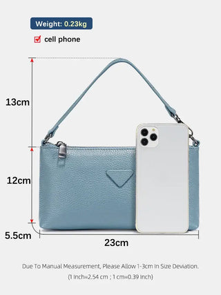 Blue leather shoulder bag with cell phone for women, stylish and versatile for casual or formal use.