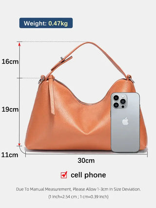Handmade leather shoulder bag in orange with dimensions, showcasing a cell phone for size comparison.