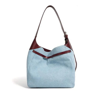 Casual women's shoulder bag in light blue with brown leather strap, stylish denim bucket tote for everyday use.