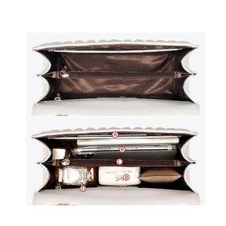 Interior view of white quilted women’s shoulder bag showcasing multiple compartments and zipper pockets.