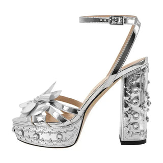 Silver high-quality handmade platform sandals with floral accent and embellished block heel, perfect for glamorous occasions.