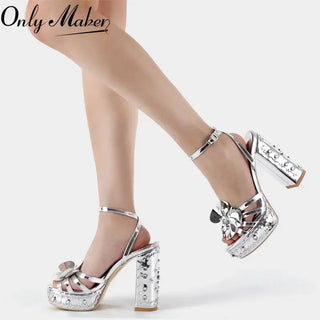 High-quality silver patent leather platform sandals with decorative flower, featuring chunky heels for added style.