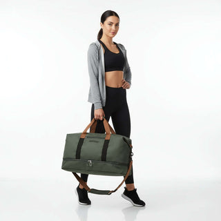 Woman in athletic wear holding a Gym Bag with Shoe Compartment, showcasing its stylish design and convenience.