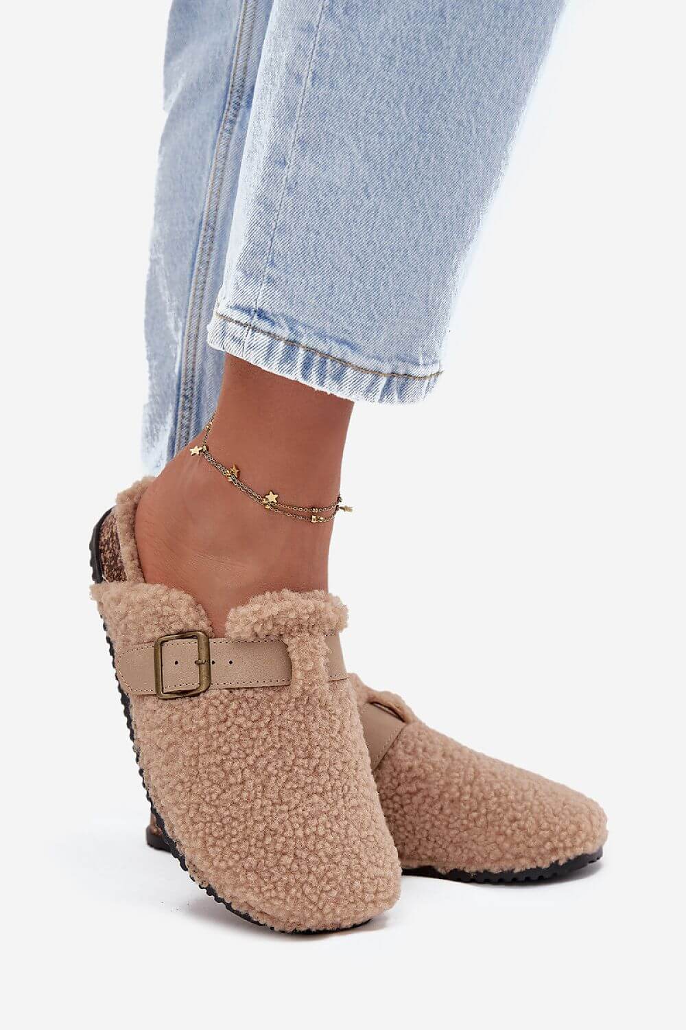 Women's sheepskin-style slippers with adjustable strap and cozy lining, perfect for comfort and style.